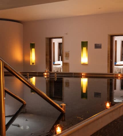 Relaxing hotel spa with warm lighting, inviting pool, and glowing candles, perfect for unwinding and rejuvenation.