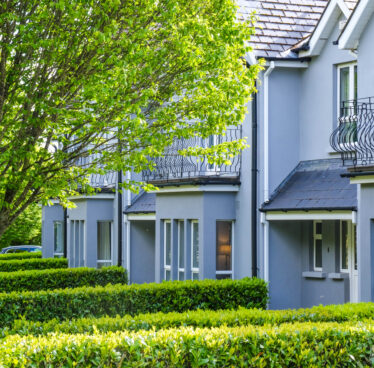 Charming hotel with lush gardens, modern balconies, and serene atmosphere, perfect for a relaxing getaway.
