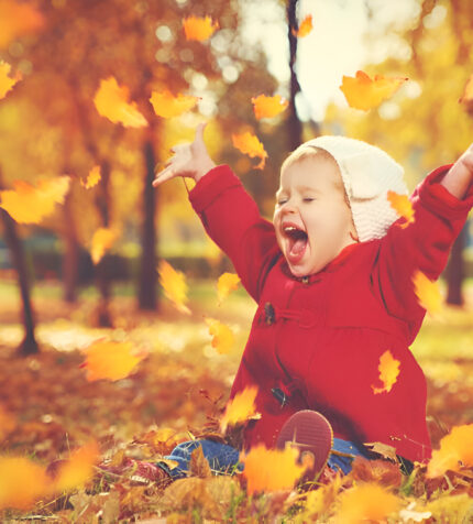 child playing in leaves