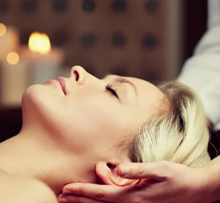 Guest enjoying relaxing massage with candlelit ambiance at luxury spa, enhancing serene hotel stay experience.